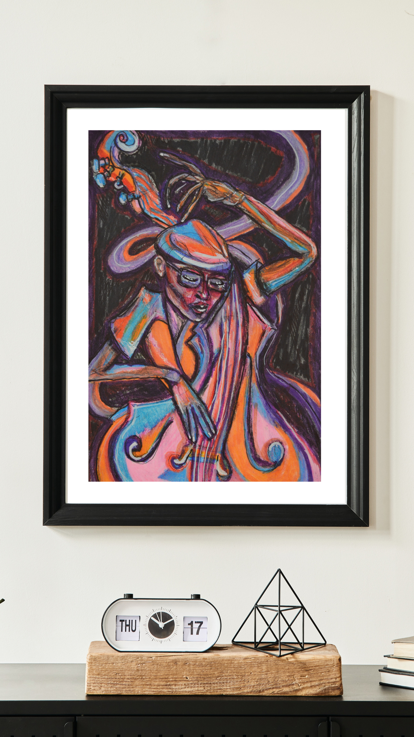 framed in sleek black, now graces a wall within an eclectic home. This vibrant, abstract artwork, alive with zesty orange and sky blue hues, captures the rhythmic dance of the double bass through its flowing strokes. A testament to musical synergy and artistic vitality, it adds a bold, modern flair to the eclectic décor, resonating with vibrant energy and captivating charm.